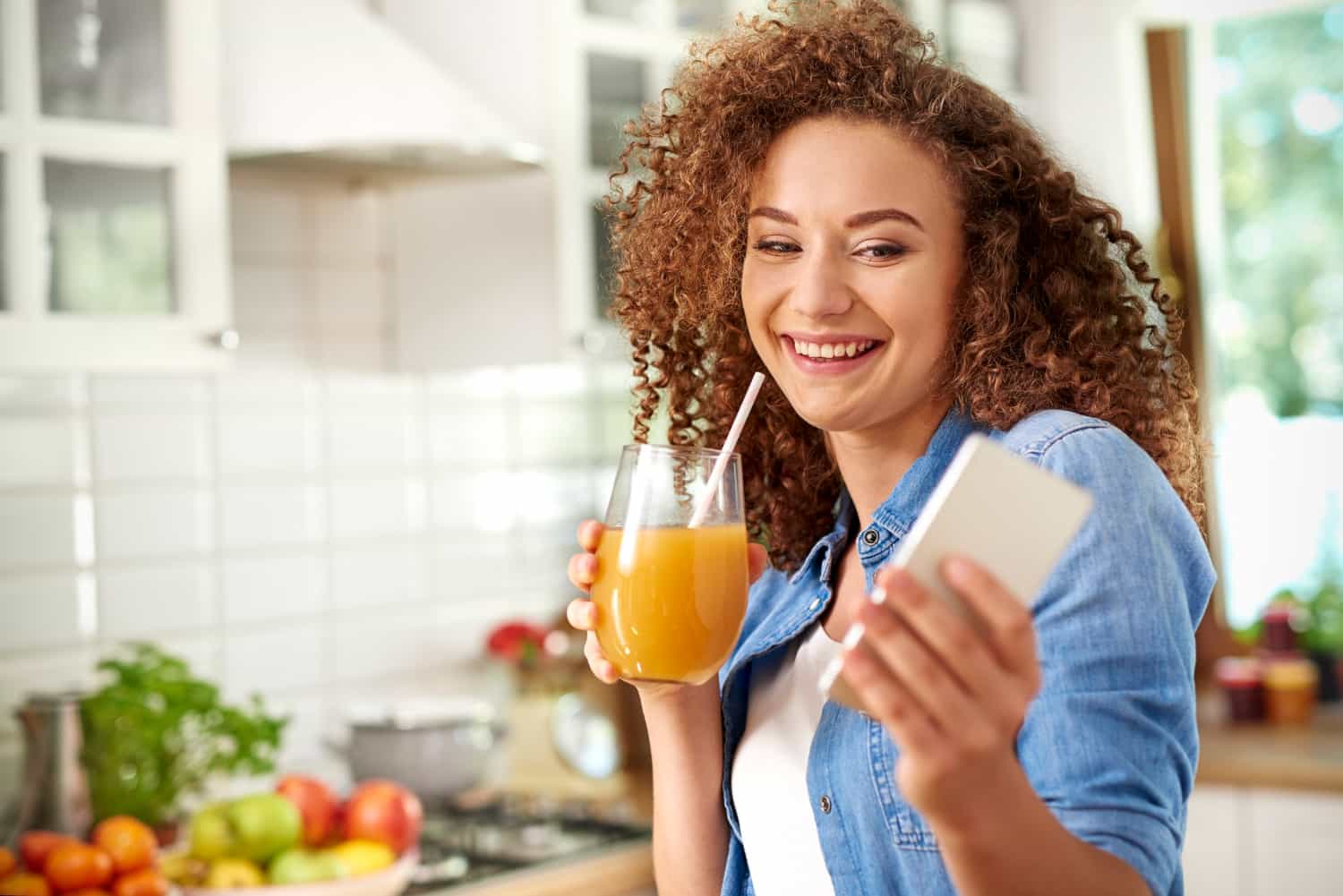 Woman holding smoothie and blood glucose meter, showcasing a natural way to lower blood sugar